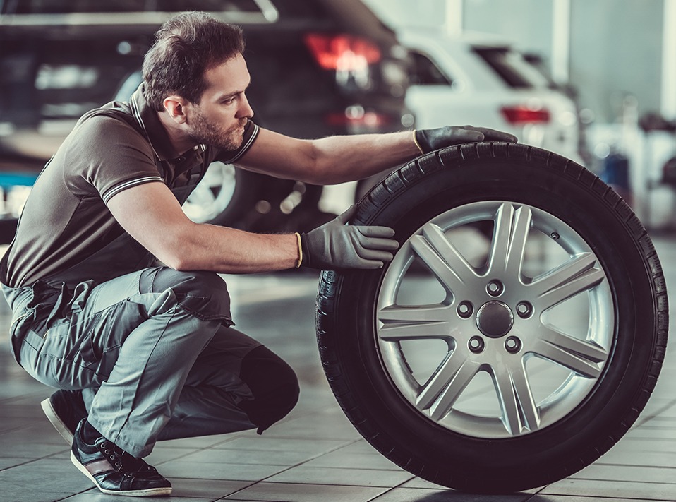 Mechanic holding and looking over a tyre - Tyres Loughborough